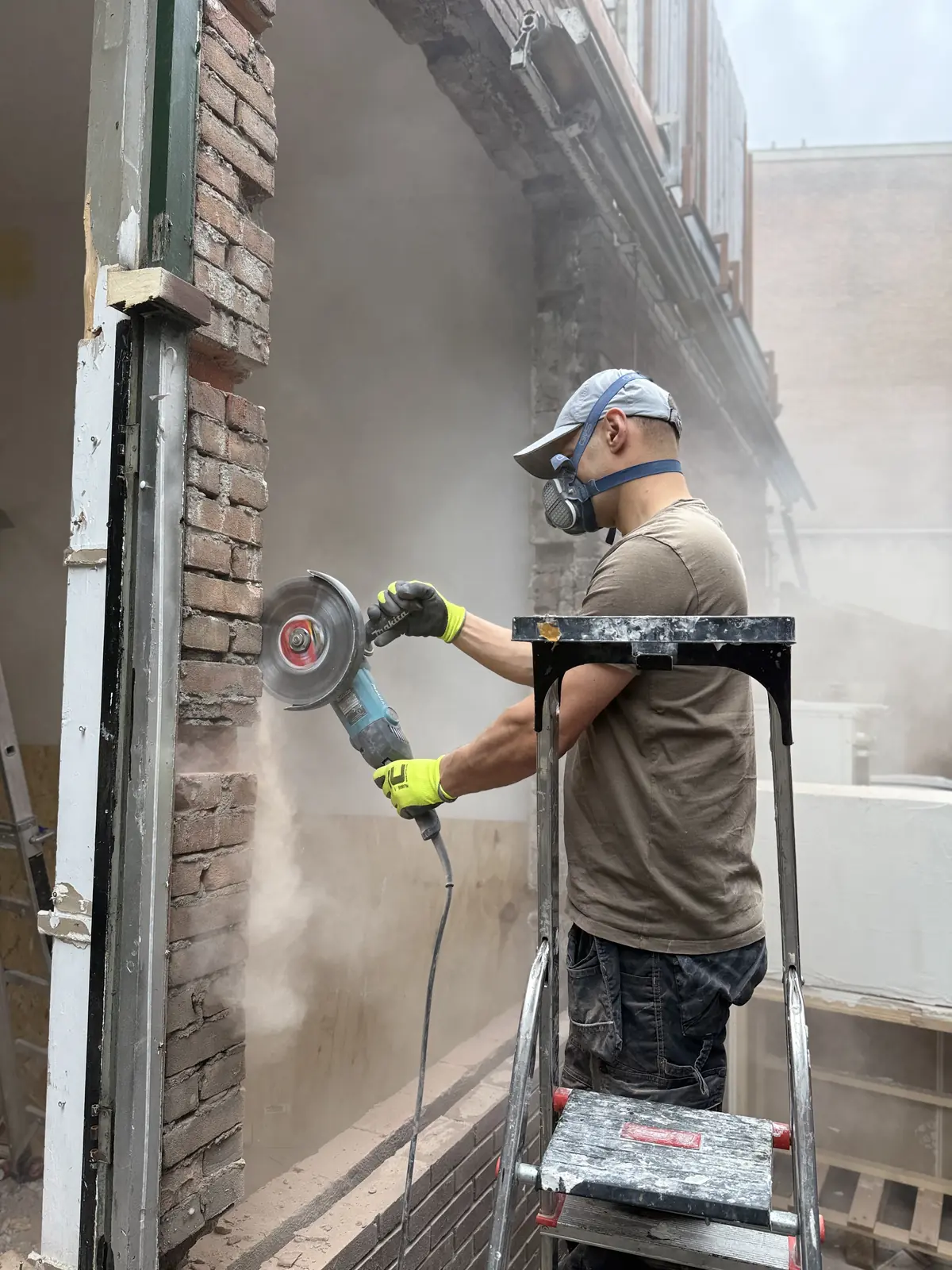Vakman van AS Solutions aan het zagen in een gevel